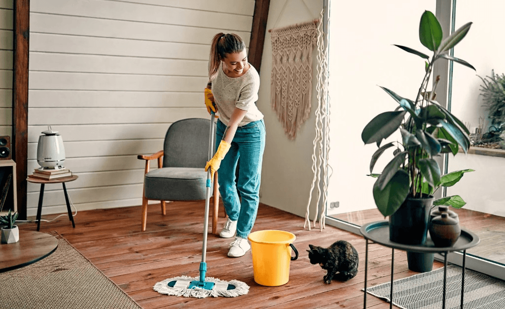 Cleaner mopping a bright living room